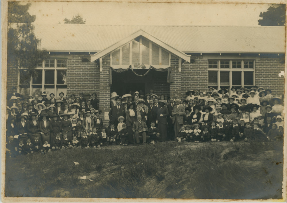 Large group of people in front of brick building 
